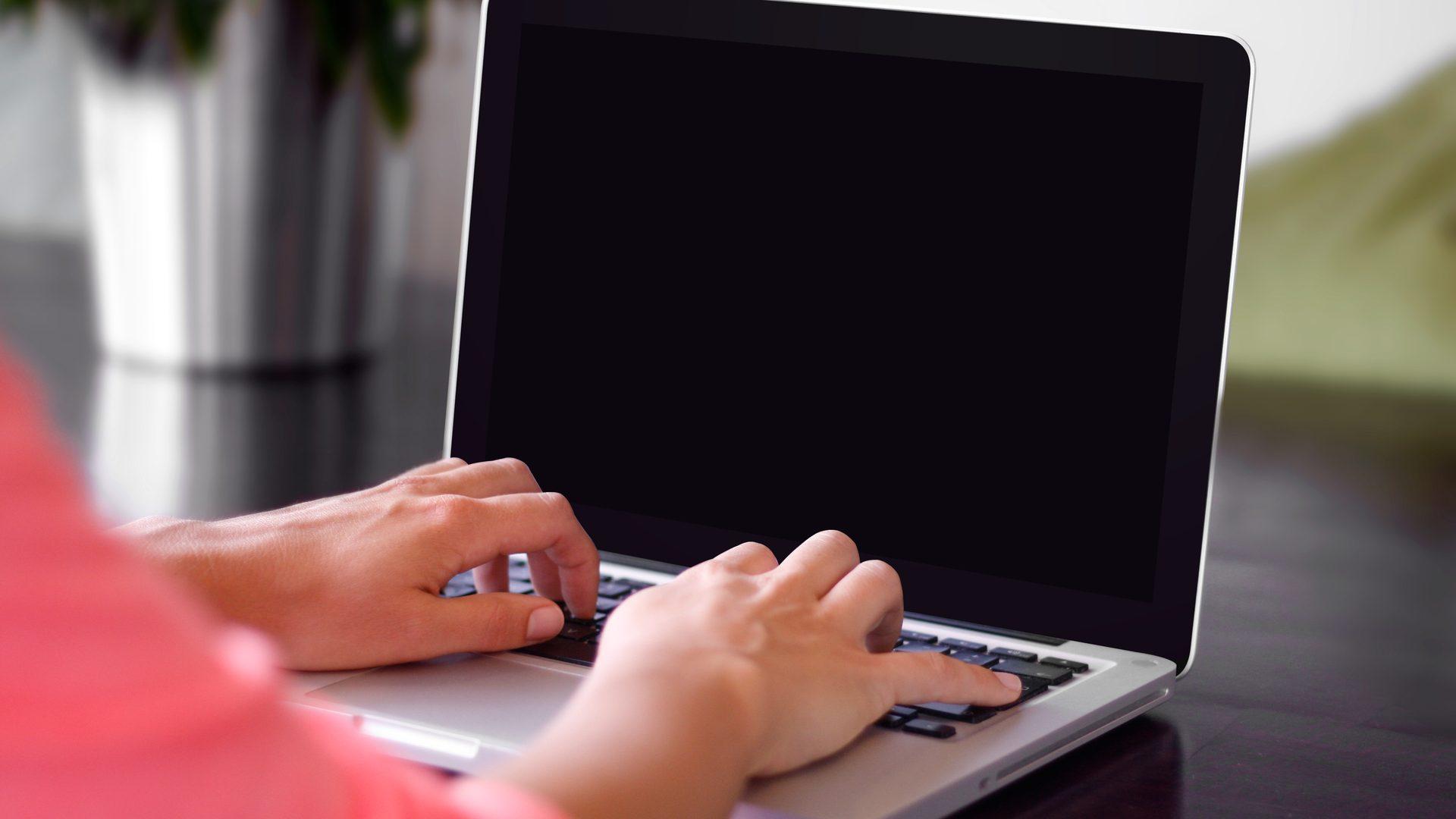 A student typing on a laptop during an online tutoring session