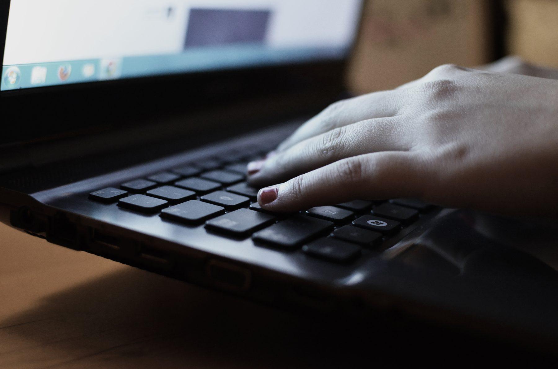 Hands typing on a laptop, representing an online tutoring session